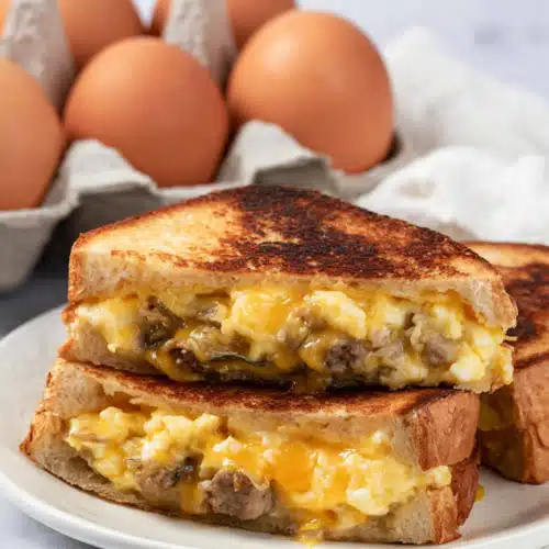 Breakfast Grilled Cheese (Easy, Cheesy & Satisfying Morning Sandwich) 8 Breakfast grilled cheese with eggs, sausage, and melted cheese on a plate