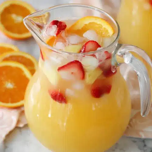 Easy Breakfast Punch Recipe: A Refreshing Morning Favorite 4 Glass pitcher of breakfast punch with citrus and strawberry slices on a light table