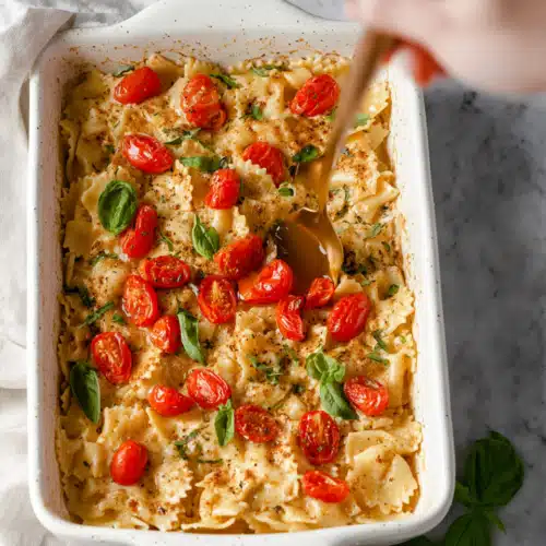 Baked Feta Pasta 9 Fluffy pancakes with maple syrup, strawberries, and blueberries on a white marble surface