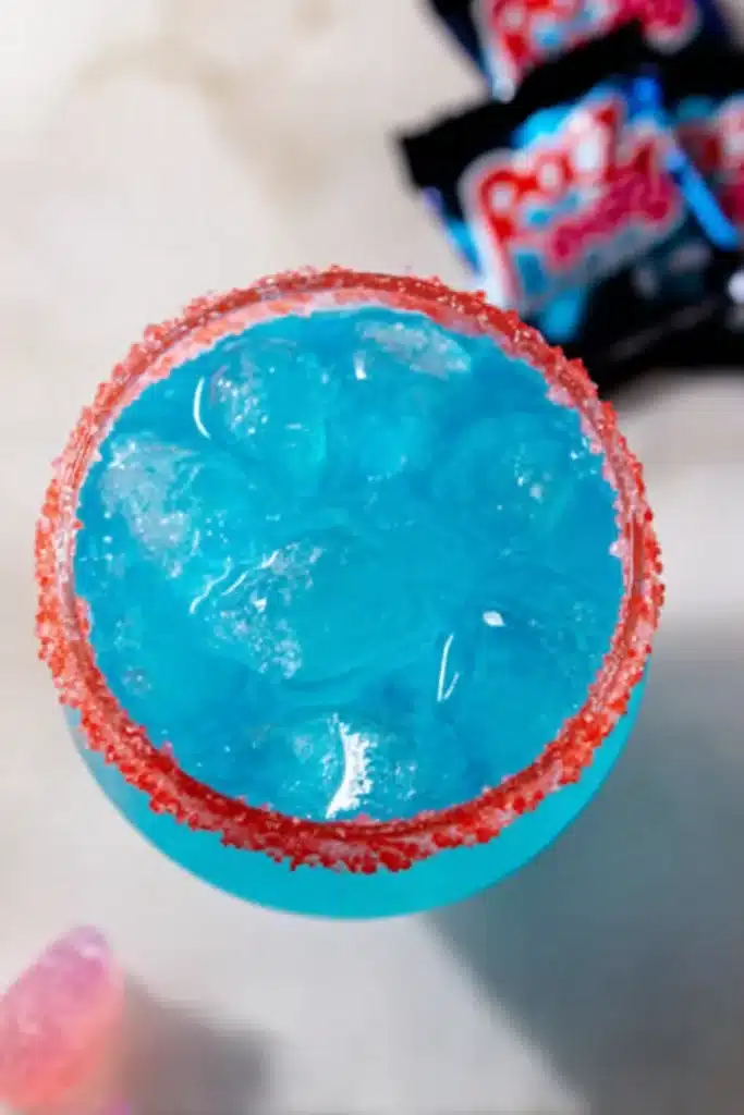 Firecracker Margarita 2 Firecracker Margarita top view with blue cocktail and red candy rim